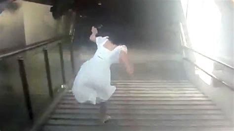 白裙女子玩手机摔下楼梯动态图